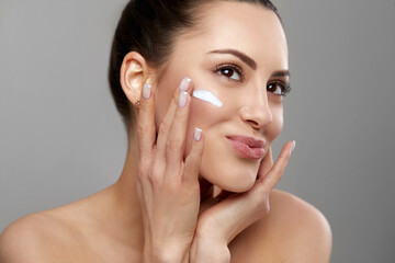 Beautiful Spa model Girl with Perfect Fresh Clean Skin. Apply moisturizing cream. Skin care.  Facial treatment. Cosmetology