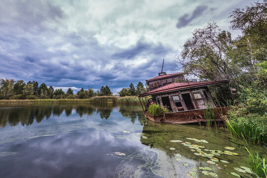 Sinking boat on a Yanov backwater in Pripyat abandoned city in Chernobyl Exclusion Zone, Ukraine