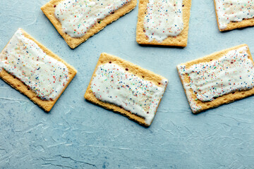 Pop tarts design. Poptart toaster pastry with icing on a blue slate background, overhead flat lay...
