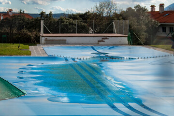 Swimming pool covered with a blue tarp ready to spend the winter