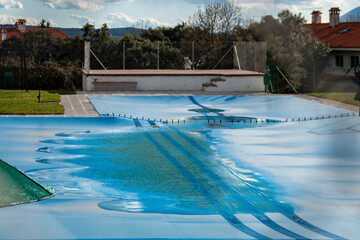 Swimming pool covered with a blue tarp ready to spend the winter