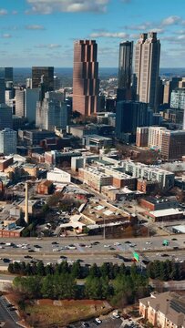 Autumn city of Atlanta. Aerial view of Buckhead Atlanta road traffic flow with skyline buildings, Georgia, USA. Vertical video.