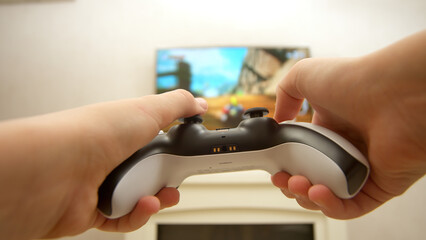 Close-up of a professional gamer's hands operating a PS controller. Home game console, modern...
