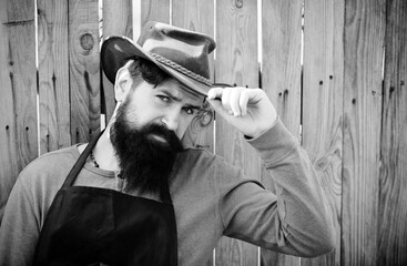 Portrait of bearded gardener on wooden background. Handsome man spend time in the farm. Worker...