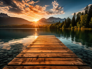 A sunset over a lake with mountains in the background - obrazy, fototapety, plakaty