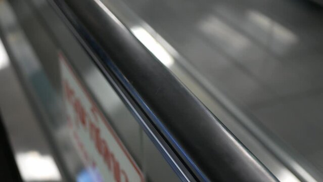 selective focus close up to the handrail of moving escalator in airport terminal or department store while operating