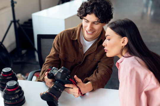 Photographer sharing camera screen with model after studio session