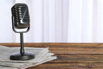 Newspapers and vintage microphone on wooden table, space for text. Journalist's work - obrazy, fototapety, plakaty
