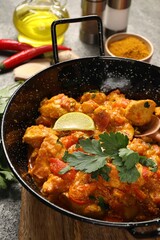 Delicious chicken curry in frying pan on table
