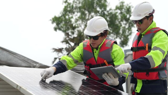 engineer men inspect modules of photovoltaic cell panels. Industrial Renewable energy of green power. workers prepare materials before construction on site with the stack of panels at background.