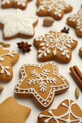 Tasty Christmas cookies with icing and spices on white background, closeup