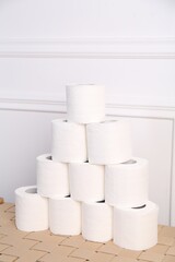 Pyramid of toilet paper rolls on wicker table