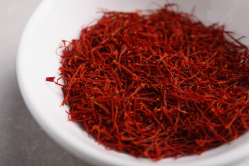 Aromatic saffron in bowl on table, closeup
