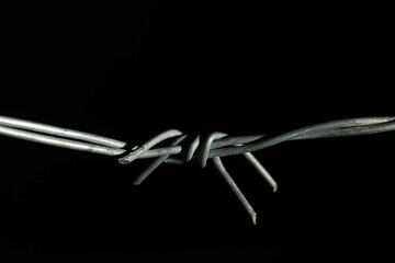 Metal barbed wire on black background, closeup