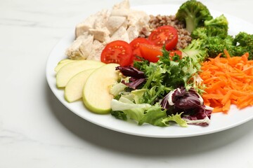 Balanced diet and healthy foods. Plate with different delicious products on white marble table, closeup