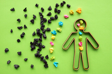 Resilience and negativity managing concept. Black paper balls surround the figurine with colored...