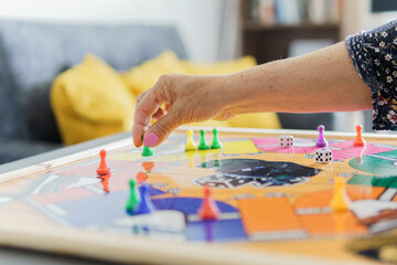a woman's hand playing ludo at home in the living room
