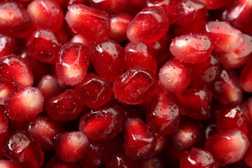 Ripe juicy pomegranate grains with water drops as background, top view