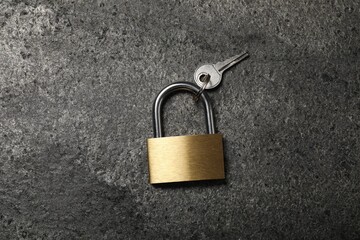 Fototapeta premium Steel padlock with key on grey table, top view