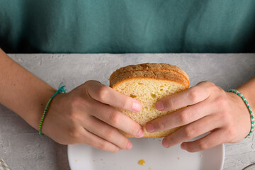 woman hands holding a sandwich with honey and peanut butter of wheat bread on white plate, to have a breakfast, close up. Typical snack food, food lifestyle, american breakfast, ready to eat