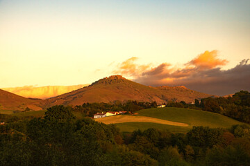 French Basque country landscape in beautiful golden sunset light. Traditional farm houses, fields...