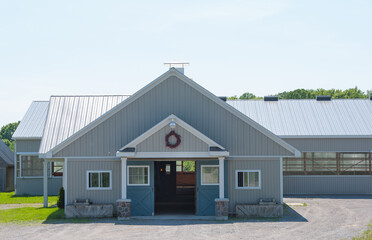 entrance way of large barn or equine facility on rural property grey siding peaked roof nice...
