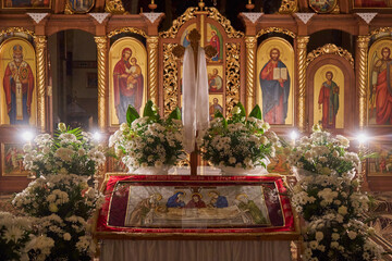 shroud in the church, the interior of the church at night with the shroud decorated with flowers, Easter Friday