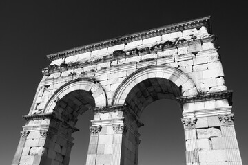 Ancient Roman arch (Arch of Germanicus) in Saintes, Charente-Maritime, France in sunny says and blue sky at background. Travel, sightseeing, tourist attraction concept. Black white historic photo.