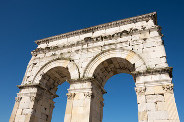 Ancient Roman arch (Arch of Germanicus) in Saintes, Charente-Maritime, France in sunny says and blue sky at background. Travel, sightseeing, tourist attraction concept.