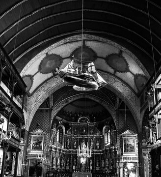 Church of St. John Baptist in Saint-Jean-de-Luz, France. Interior with hanging ship, wooden galleries, golden altar. One of the most representative churches of French Basque Country. Black white photo