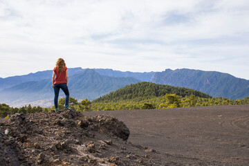 Naklejka premium Young woman and sunset in Llano del Jable, La Palma, Canary islands.