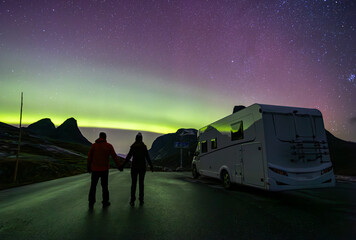 Northern lights and motorhome camper and couple in Trollstigen road, Norway - obrazy, fototapety, plakaty