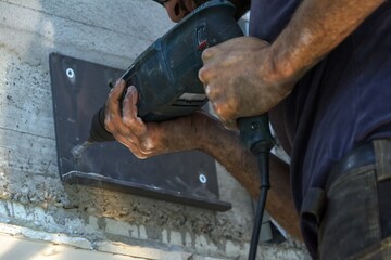 Locksmith drills a hole and attaches a steel plate.