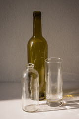 Empty bottles and a glass. long shadow and refraction patterns. Caustic