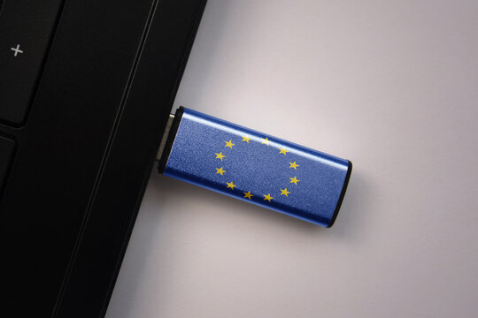 usb flash drive in notebook computer with the national flag of european union on gray background.