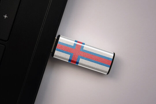 usb flash drive in notebook computer with the national flag of faroe islands on gray background. - Powered by Adobe
