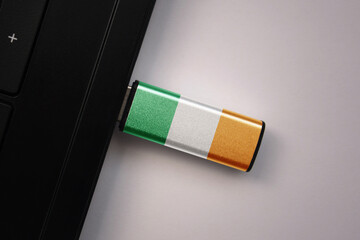 usb flash drive in notebook computer with the national flag of ireland on gray background.