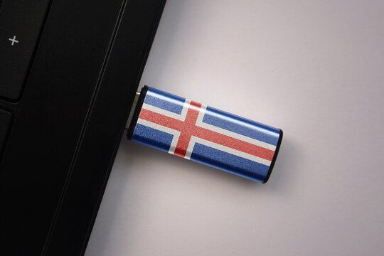 usb flash drive in notebook computer with the national flag of iceland on gray background.