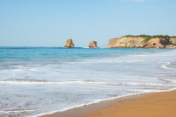 Hendaye sandy beach landscape with beautiful twin huge rocks at background. Nouvelle-Aquitaine, France.