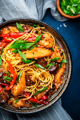 Hot stir fry egg noodles with turkey, paprika, mushrooms, chives and sesame seeds with ginger,...