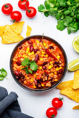 Chili con carne, mexican dish with minced beef, red beans, paprika, corn and hot peppers in spicy tomato sauce, tex-mex cuisine, white background, top view