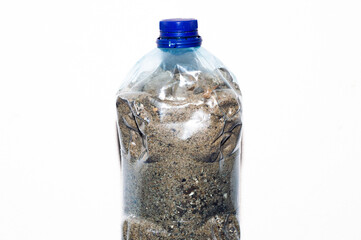 a very large single bottle on a light white background filled with sand for an exercise