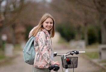 Smiling Girl Holds Bicycle In Spring With Blurred Park Background - 755875729