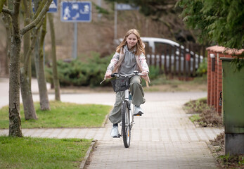 Girl Rides Bicycle Among Private Houses In Europe During Spring - 755876385