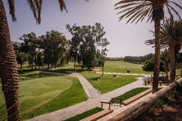 Agadir, Morocco - February 28, 2024- A view of a golf course with palm trees, green grass, a clear...