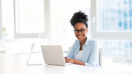 Fototapeta premium The young businesswoman smiles as she works on her laptop in the office