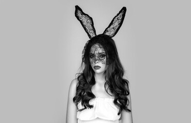 Portrait of desire woman in bunny ears. Studio shot young woman wearing bunny ears. Sexy brunette beautiful woman posing in black bunny mask on grey background.
