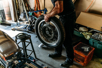 Man with motorcycle wheel and tire 1