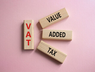 VAT - Value Added Tax symbol. Wooden cubes with word VAT. Beautiful pink background. Business and Value Added Tax concept. Copy space.