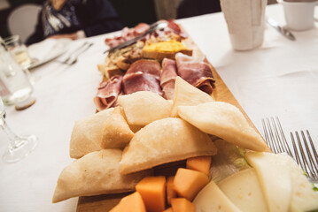 Fried pizza Bolognese style placed on a cold cuts board